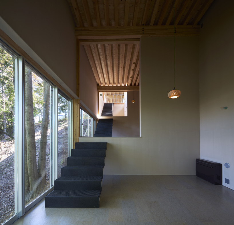 OHArchitecture embeds stepped camma villa and office onto sloping site in otsu, japan