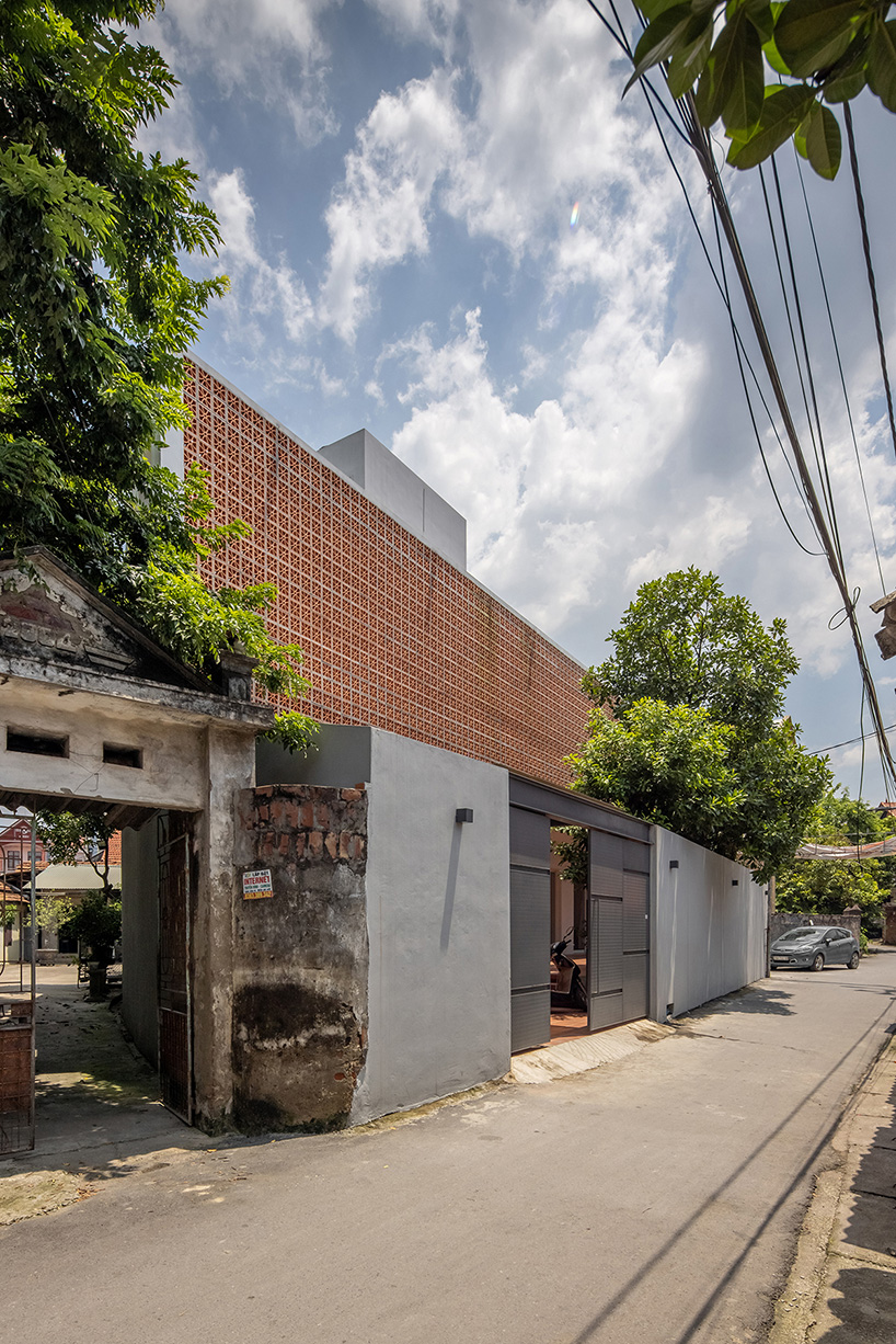 perforated double-skin brick facade shields grand house in vietnam