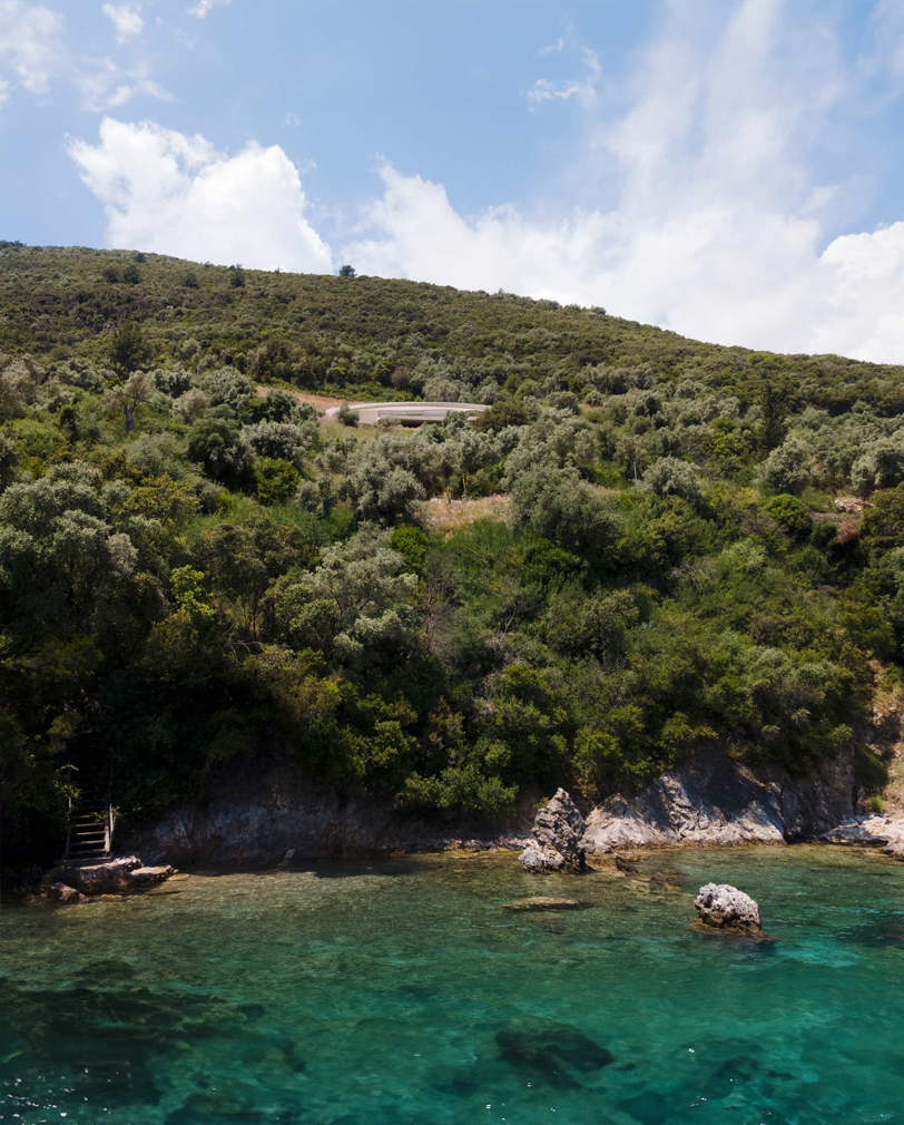 La silueta curvilínea de la casa Thyta se extiende a lo largo del paisaje montañoso de Lefkada, Grecia.