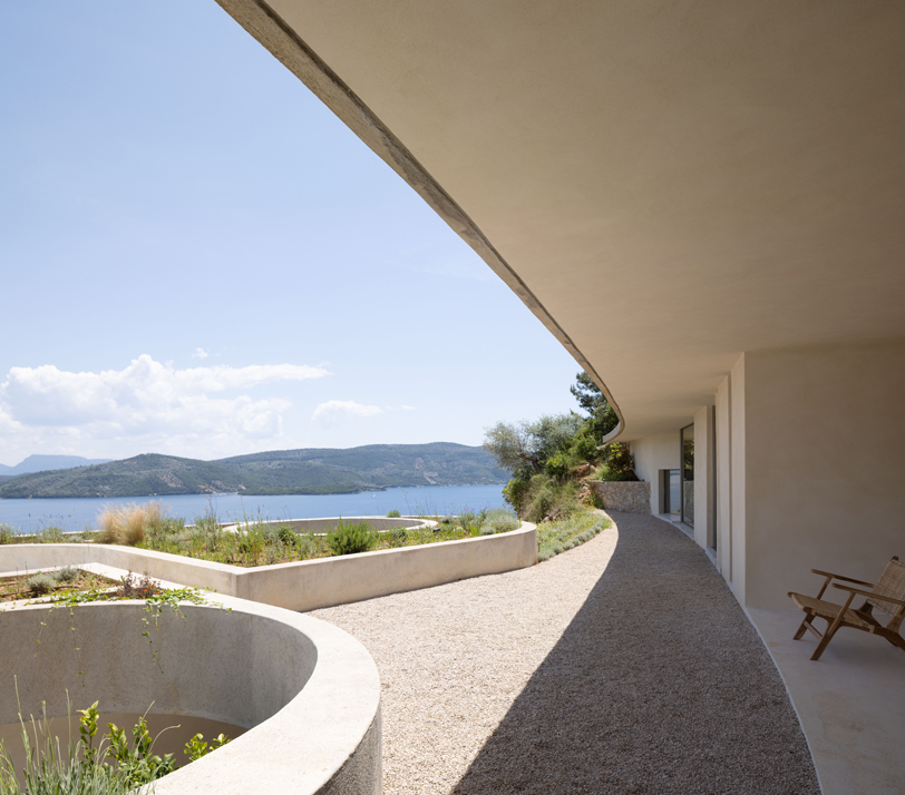 La silueta curvilínea de Thyta House se extiende a lo largo del paisaje montañoso de Lefkada, Grecia.