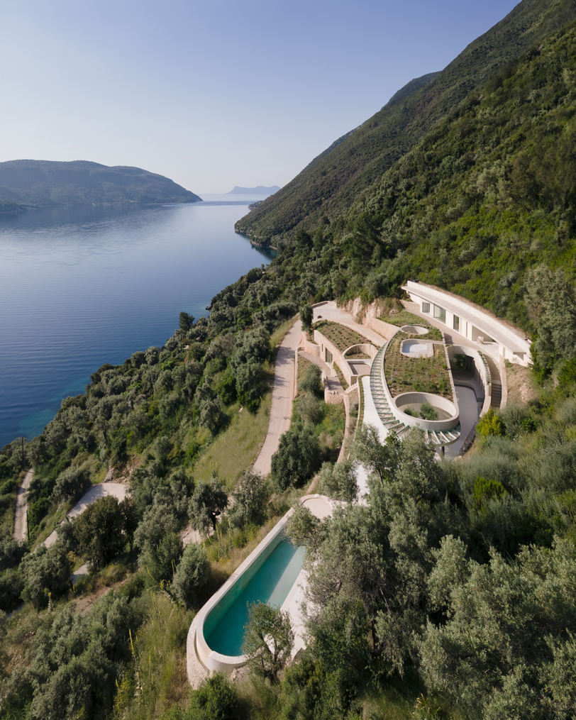 La silueta curvilínea de Thyta House se extiende a lo largo del paisaje montañoso de Lefkada, Grecia.