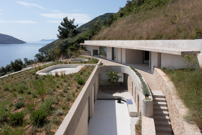 La silueta curvilínea de Thyta House se extiende a lo largo del paisaje montañoso de Lefkada, Grecia.