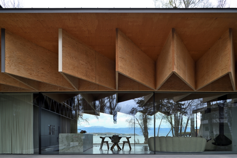 Paneles de madera tipo origami se despliegan sobre la casa Bachholz en el lago de Ginebra