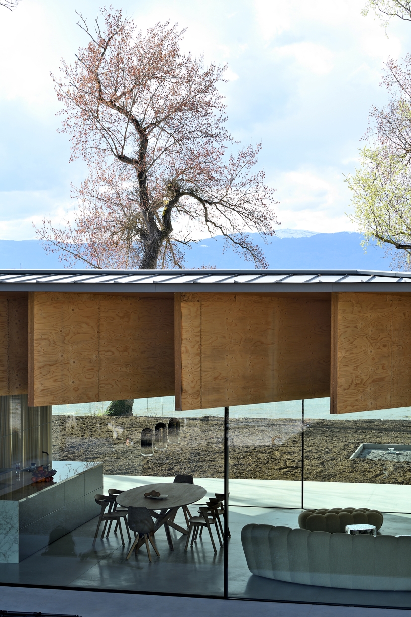 Paneles de madera tipo origami se despliegan sobre la casa Bachholz en el lago de Ginebra