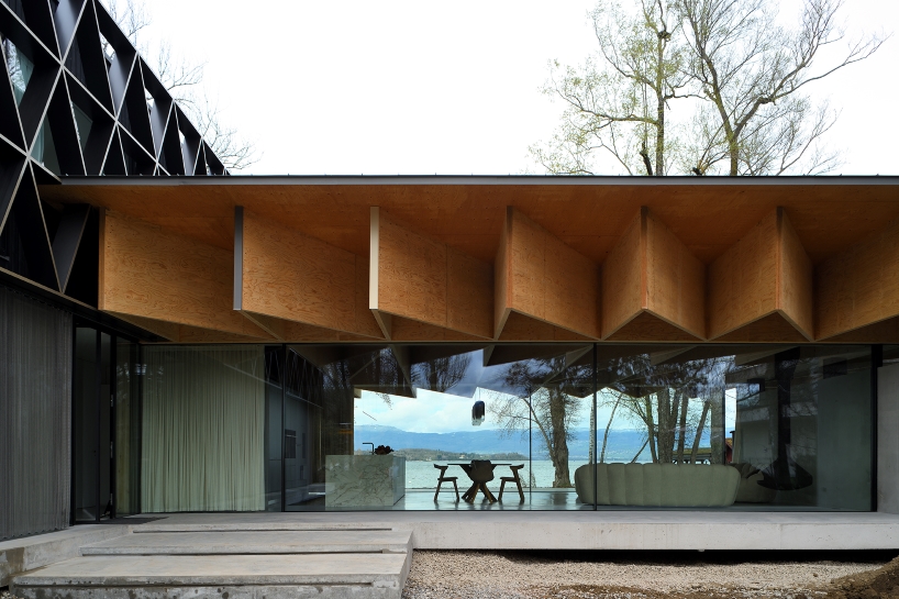 Paneles de madera tipo origami se despliegan sobre la casa Bachholz en el lago de Ginebra