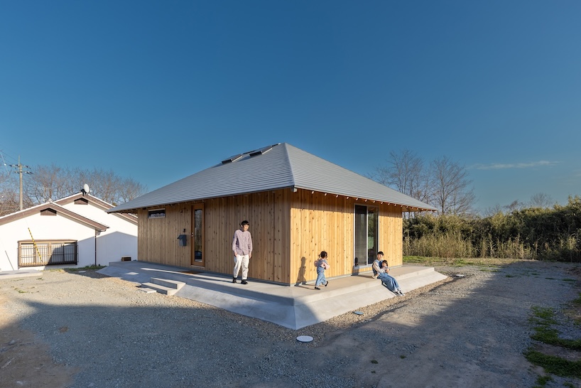 une maison en bois par architrip s'étend de manière fluide dans le jardin environnant au Japon