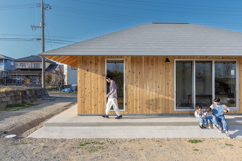 une maison en bois par architrip s'étend de manière fluide dans le jardin environnant au Japon