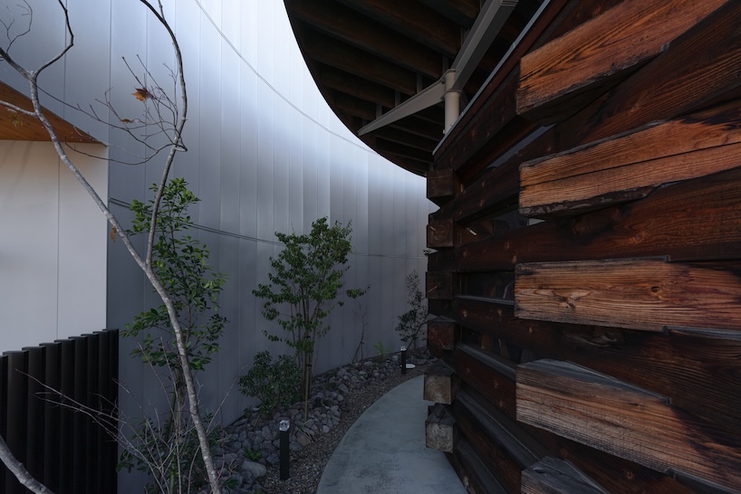 architrip's retail space curves between two existing shops in fukushima