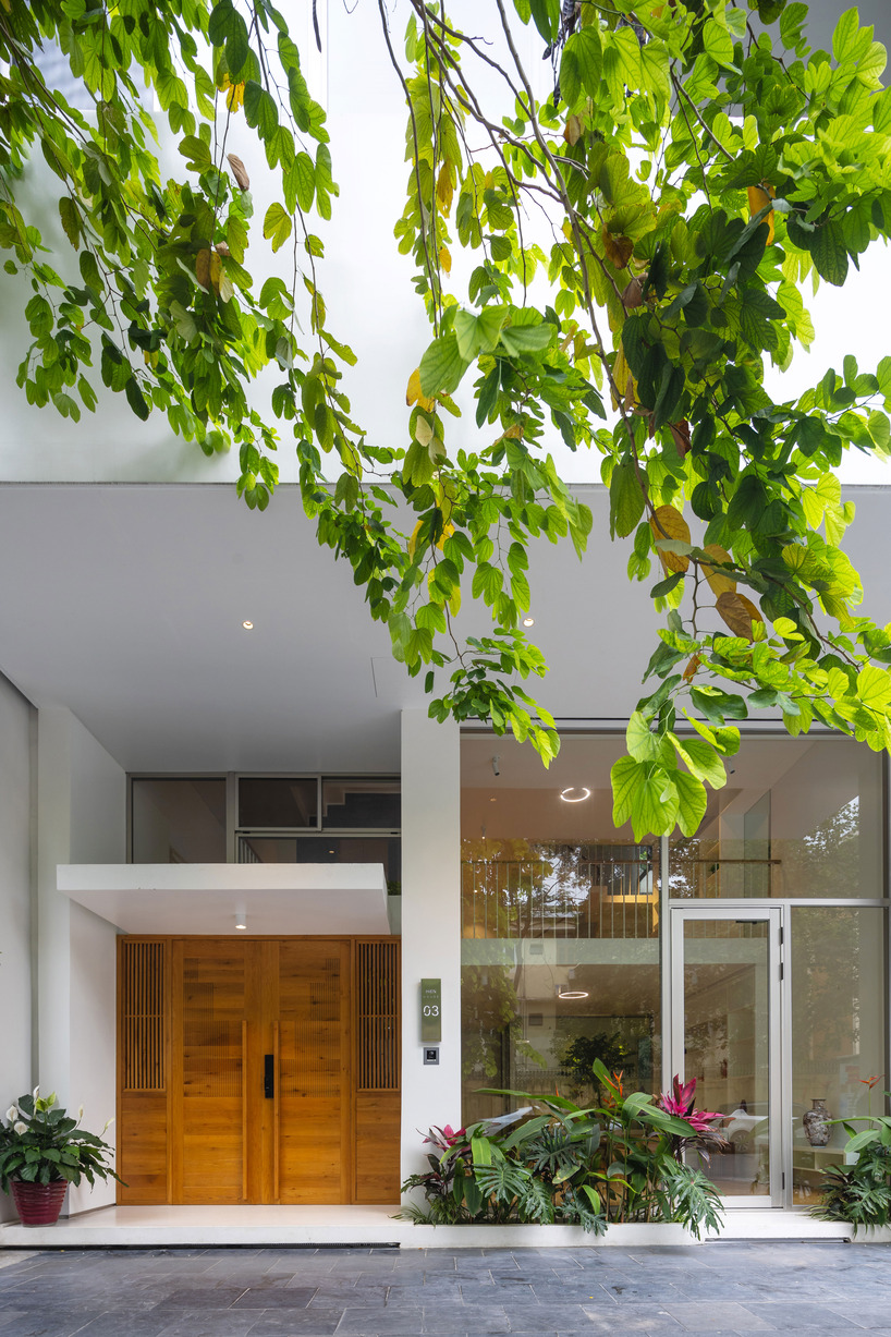 Un atrio arbolado recorre la casa de d15studio en Vietnam