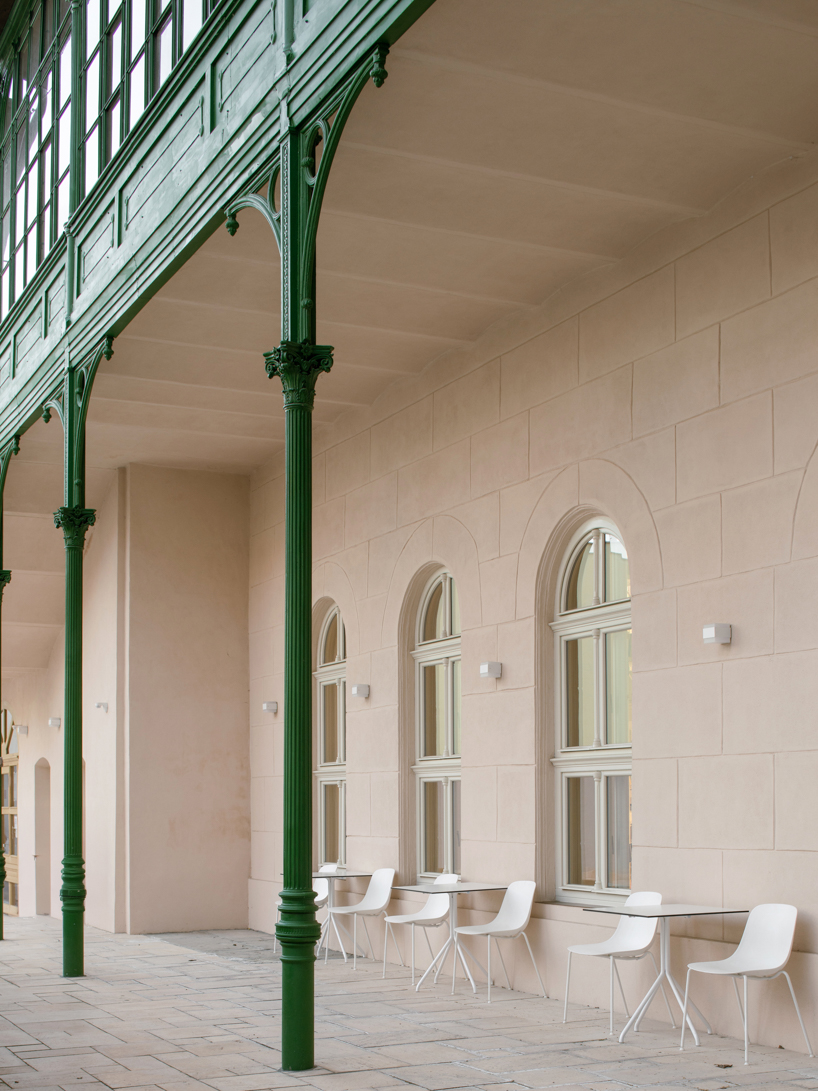 suspended steel shelving forms permeable curtain within revitalized historic slovak library