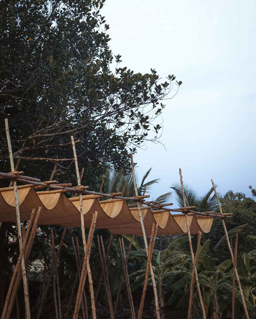 tensile fabric weaves through studio terratects' wooden trestle pavilion in india