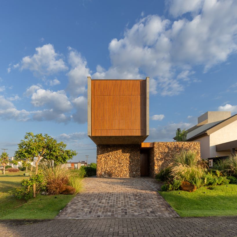 oficina conceito arquitetura's cantilevering house rests upon stone volume in brazil