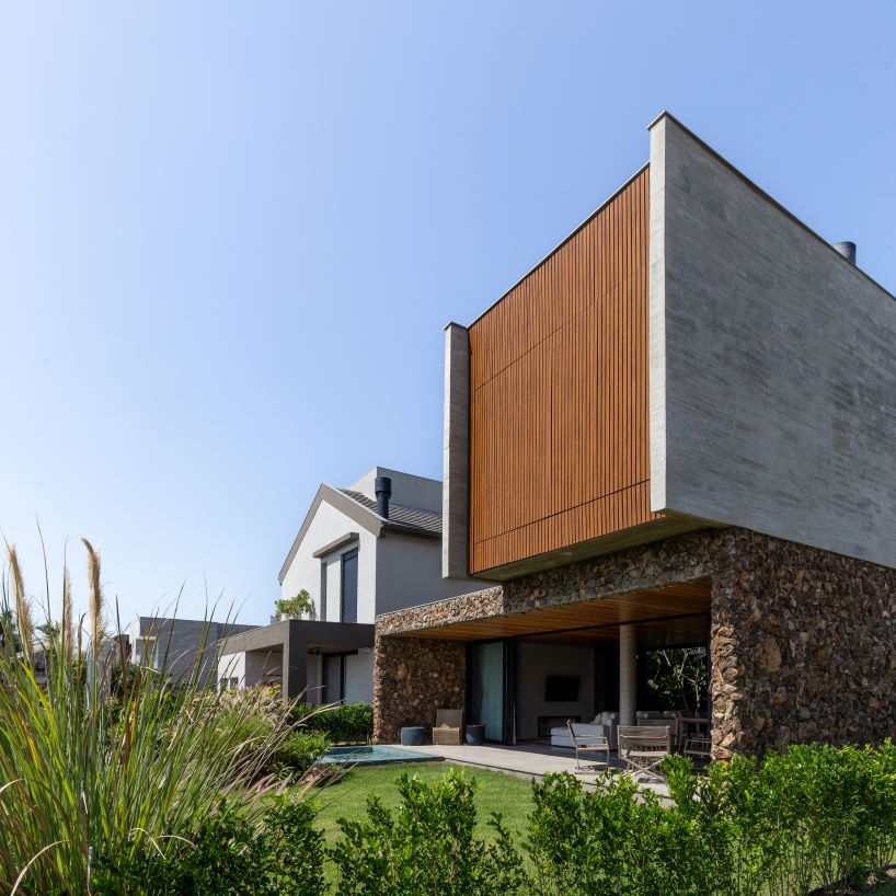 Oficina conceito arquitetura's cantilevered house rests on a stone volume in Brazil