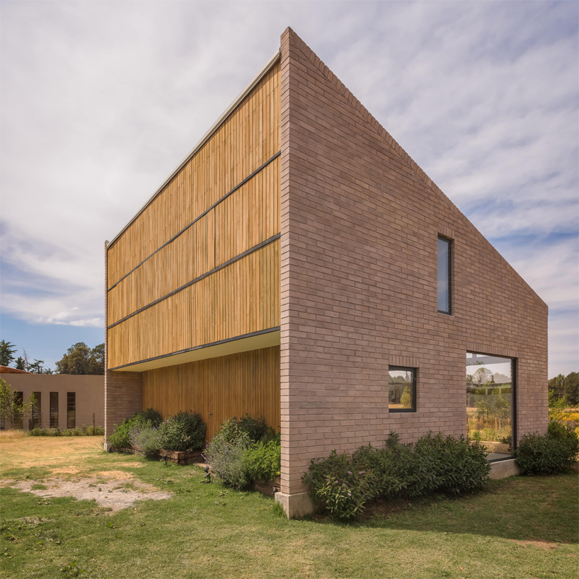 Una pequeña casa geométrica de ladrillo de Estudio Atemporal Crafts en el paisaje rural de México