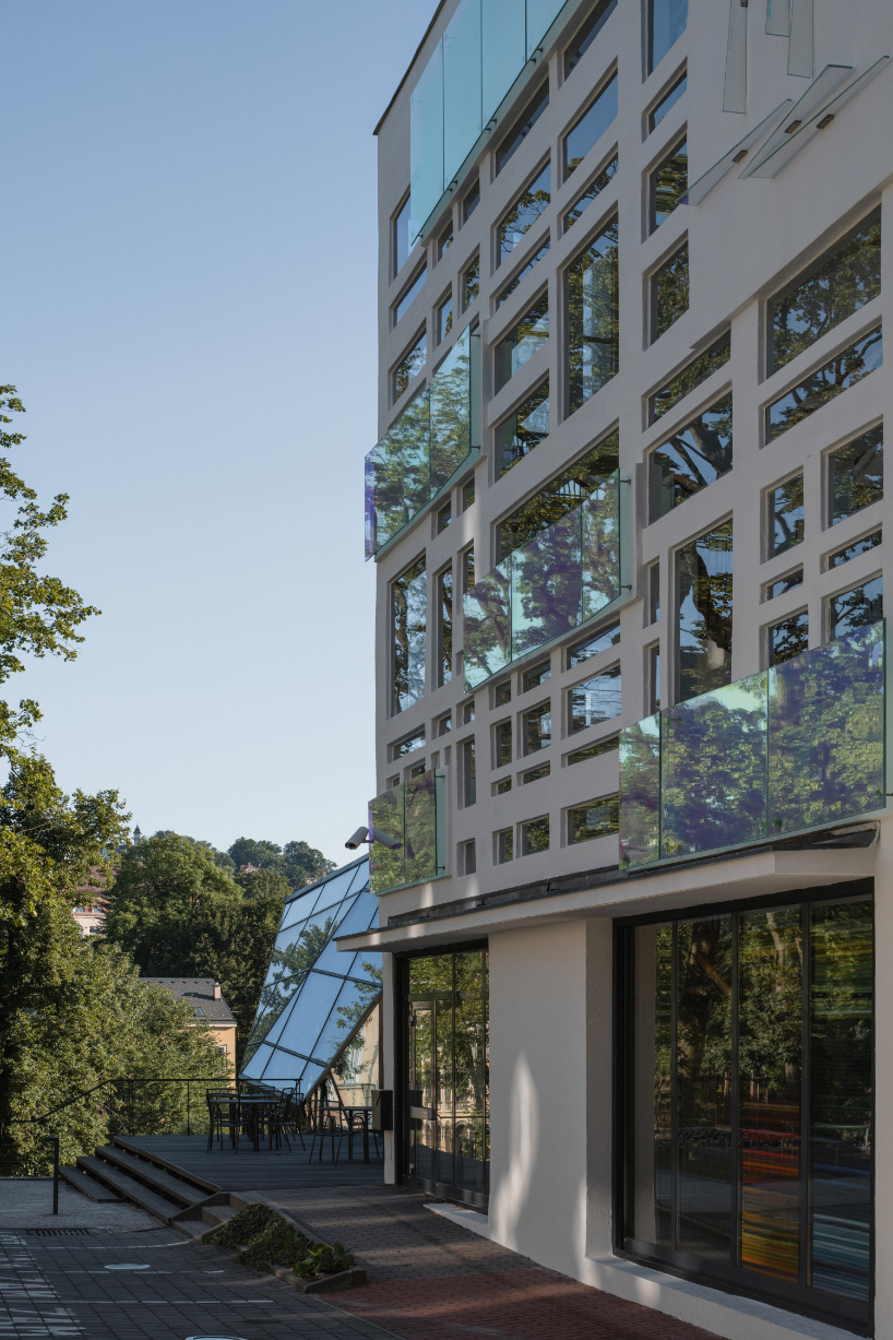 dichroic glass collage by tereza šváchová wraps museum staircase in czech republic