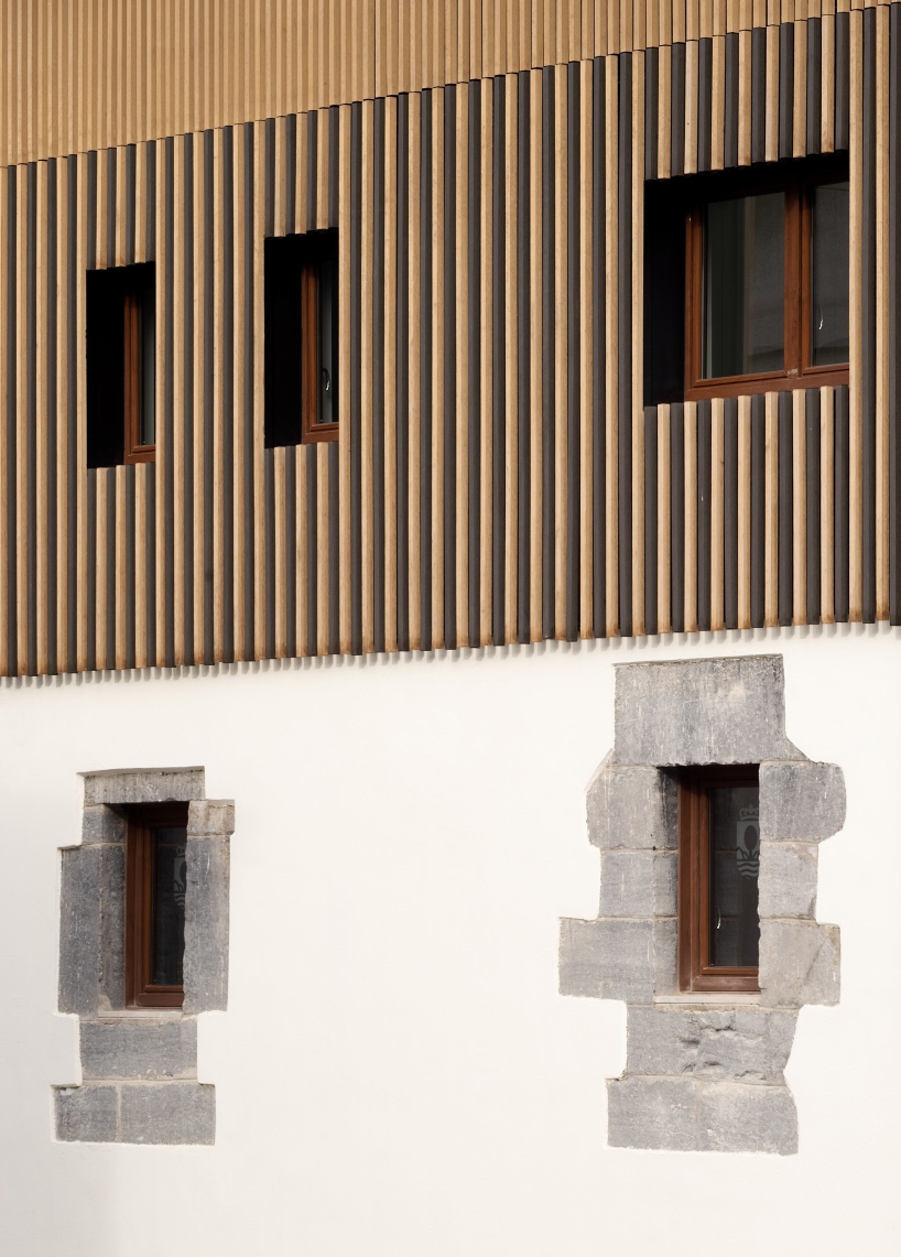 Listones de madera verticales en la fachada poliédrica del Ayuntamiento de Iluca, España