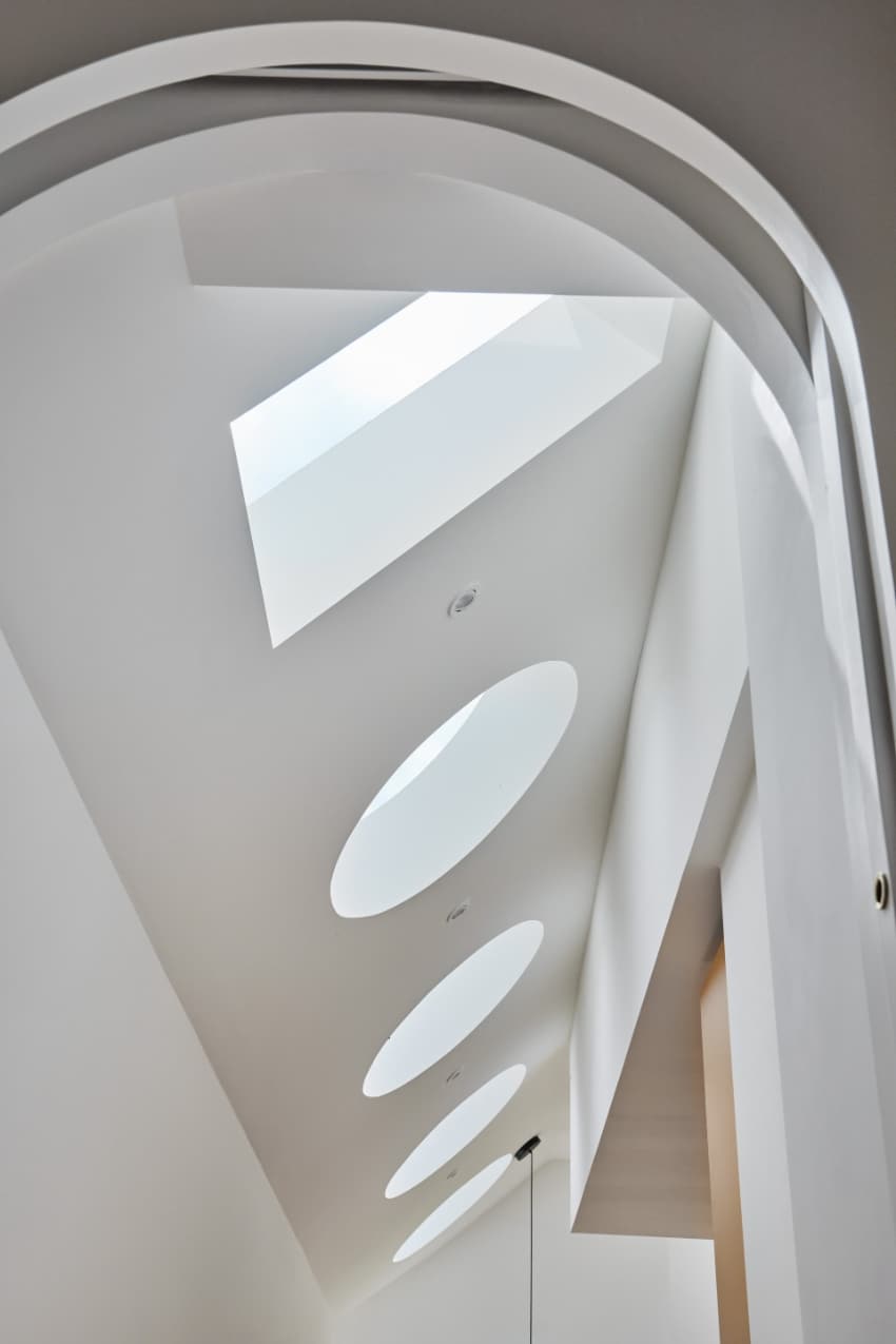 a series of square and circular skylights introduces geometric light casts within minty house