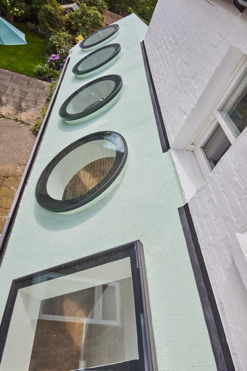 Una serie de tragaluces cuadrados y circulares introducen proyecciones de luz geométricas dentro de Mint House.