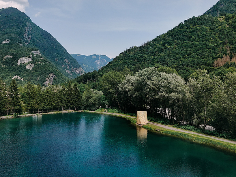 Cabañas de madera triangulares repartidas en la orilla del río cerca de los Alpes como refugio de pescadores