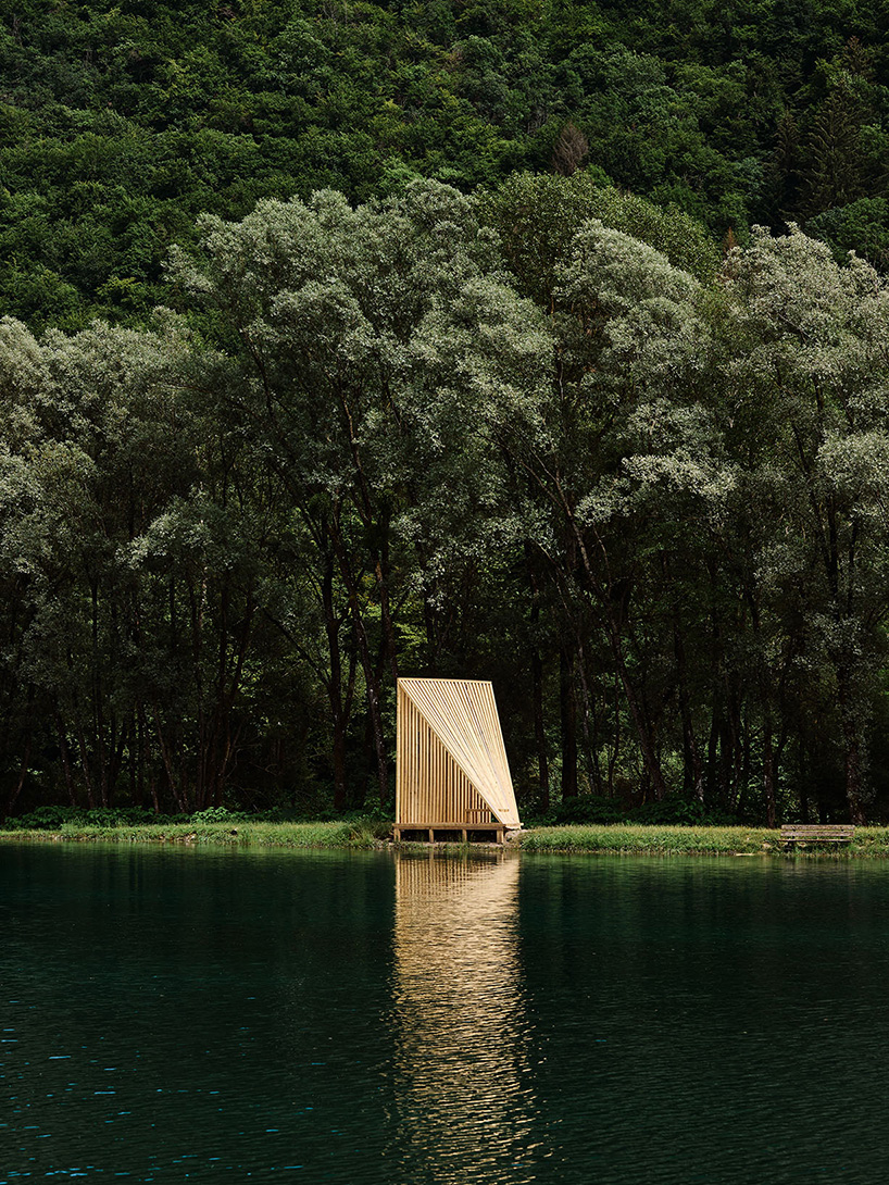 Cabañas de madera triangulares repartidas en la orilla del río cerca de los Alpes como refugio de pescadores