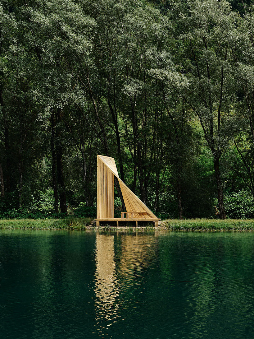 Cabañas de madera triangulares repartidas en la orilla del río cerca de los Alpes como refugio de pescadores