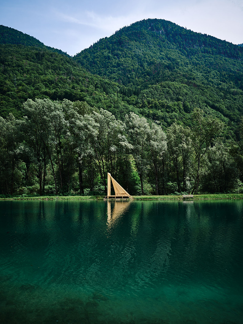 Cabañas de madera triangulares repartidas en la orilla del río cerca de los Alpes como refugio de pescadores