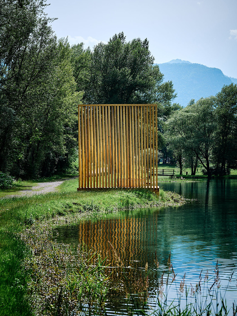 Cabañas de madera triangulares repartidas en la orilla del río cerca de los Alpes como refugio de pescadores