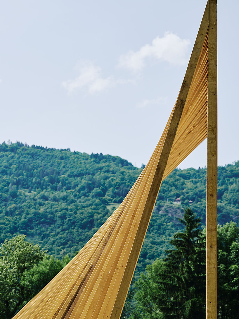 triangular wooden cabin unfolds on river's shore near alps as a fishermen's retreat