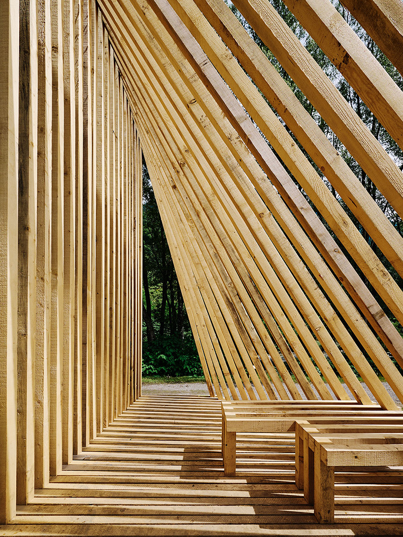 triangular wooden cabin unfolds on river's shore near alps as a fishermen's retreat