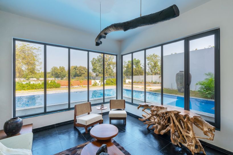 linear, unbroken wall encloses weekend villa by maanchitra in rural india