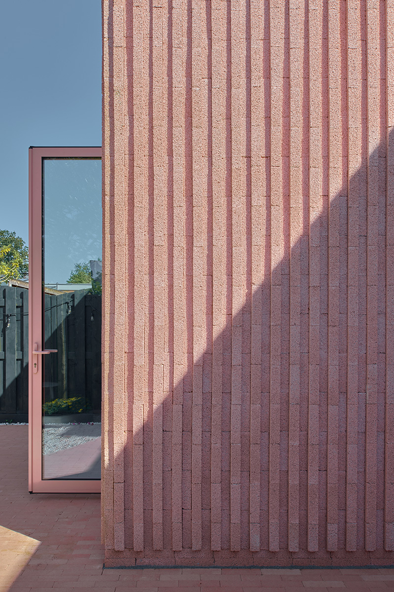 des briques de béton roses verticales enveloppent la maison Rosa des architectes d'Atlas aux Pays-Bas