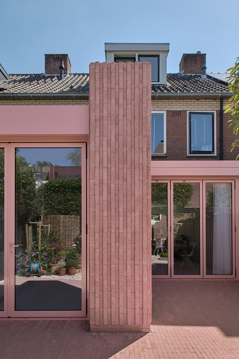 des briques de béton roses verticales enveloppent la maison Rosa des architectes d'Atlas aux Pays-Bas