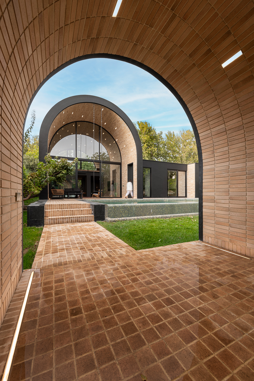 semi-enclosed vaulted residence by super void space splits across narrow water body in iran