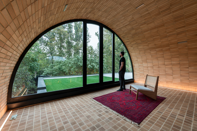 semi-enclosed vaulted residence by super void space splits across narrow water body in iran