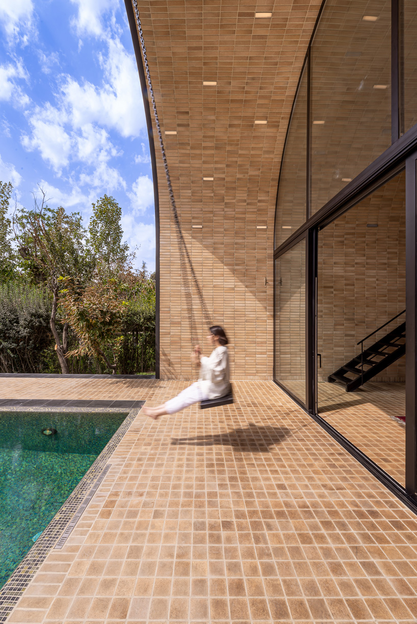 semi-enclosed vaulted residence by super void space splits across narrow water body in iran