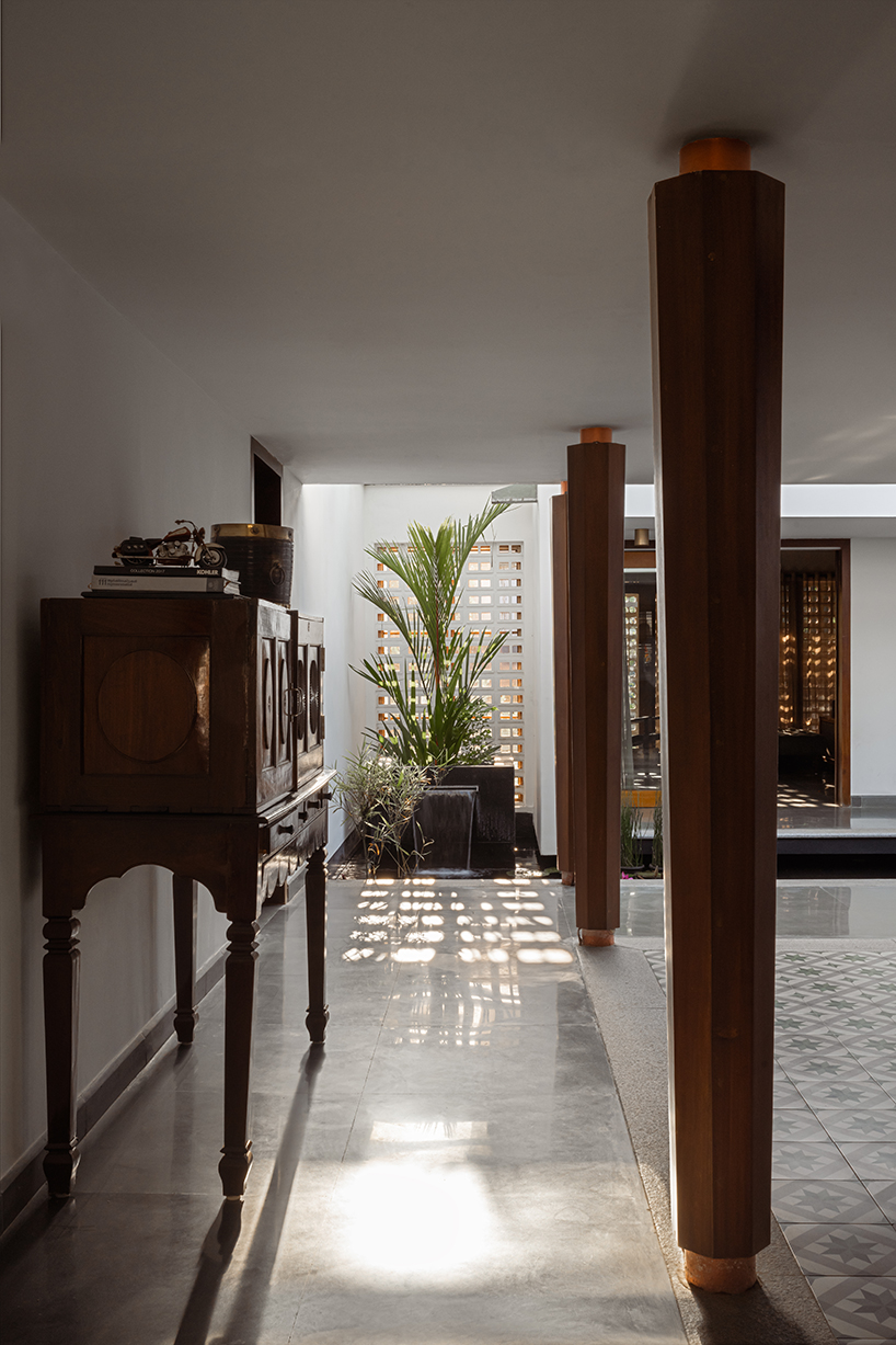 pitched roof volume cantilevers from thomas parambil's house amid kerala paddy fields