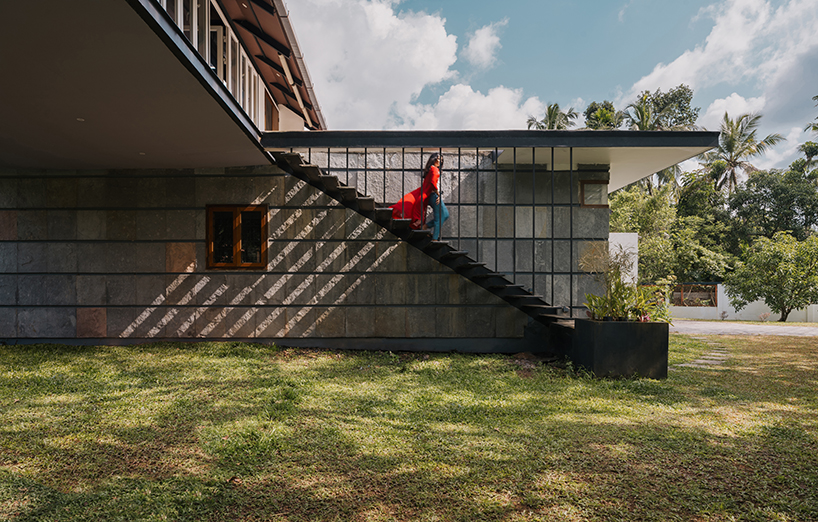 pitched roof volume cantilevers from thomas parambil's house amid kerala paddy fields