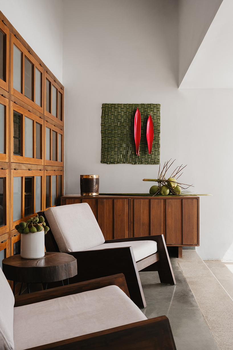 pitched roof volume cantilevers from thomas parambil's house amid kerala paddy fields