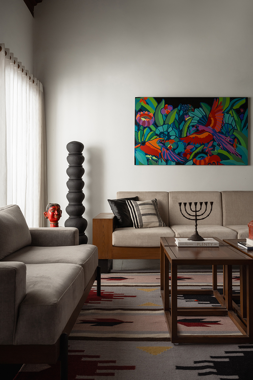 pitched roof volume cantilevers from thomas parambil's house amid kerala paddy fields