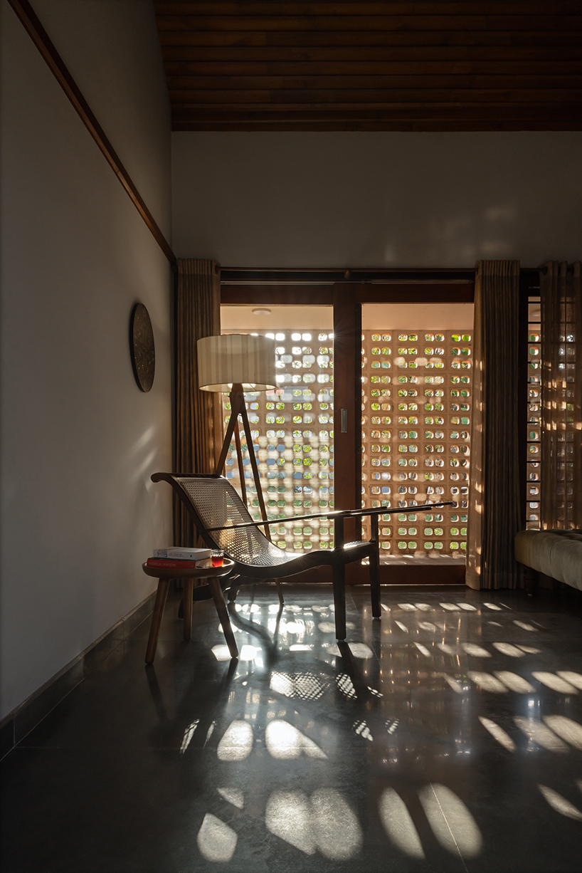 pitched roof volume cantilevers from thomas parambil's house amid kerala paddy fields
