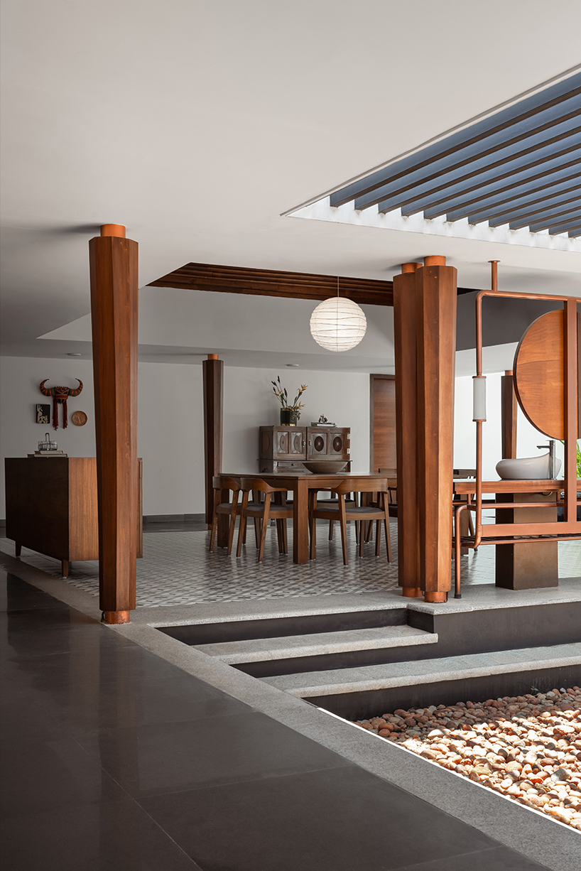 pitched roof volume cantilevers from thomas parambil's house amid kerala paddy fields