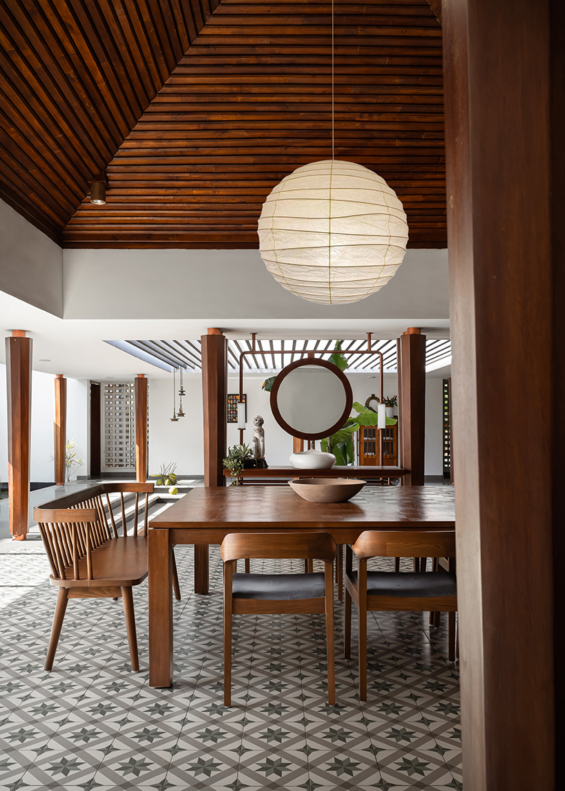 pitched roof volume cantilevers from thomas parambil's house amid kerala paddy fields