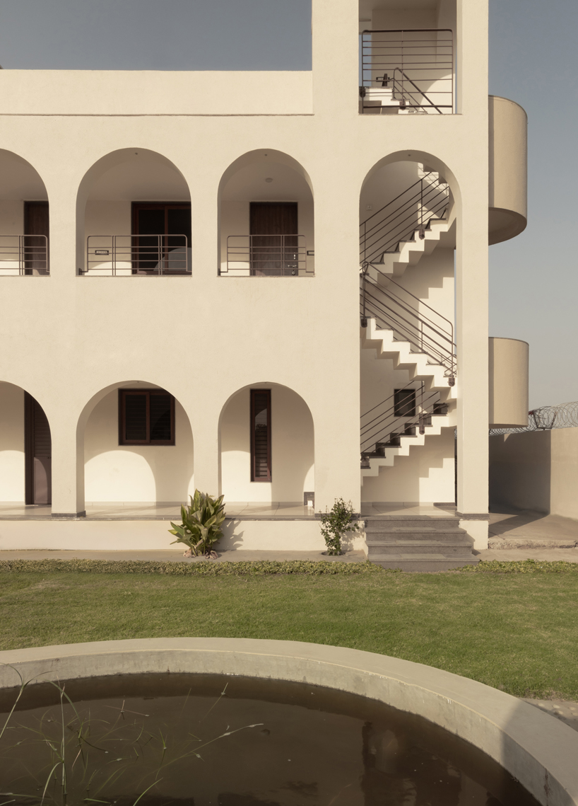 arches carve into ivory-colored walls of raasa architects' ashram in indian village