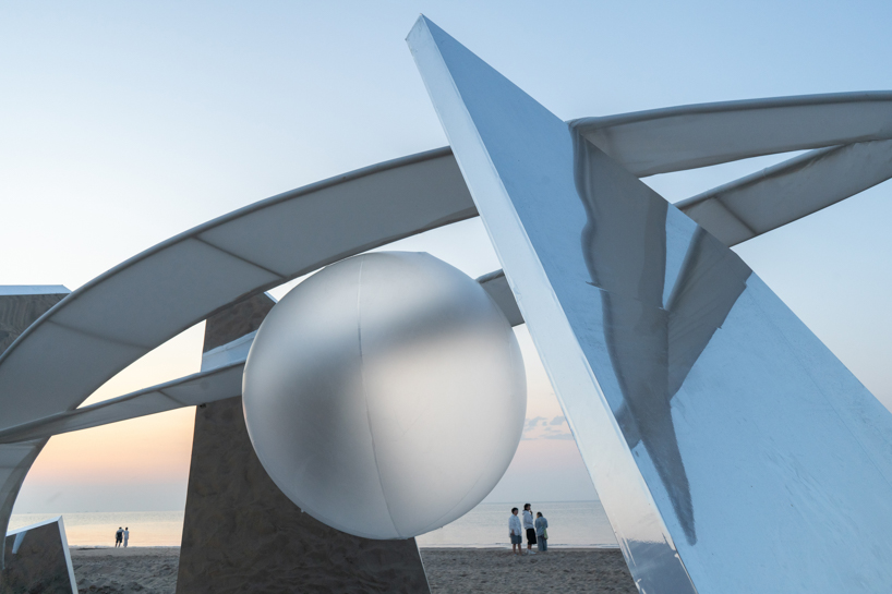 two suspended white wings float around luminous central sphere for oas/s-nest installation