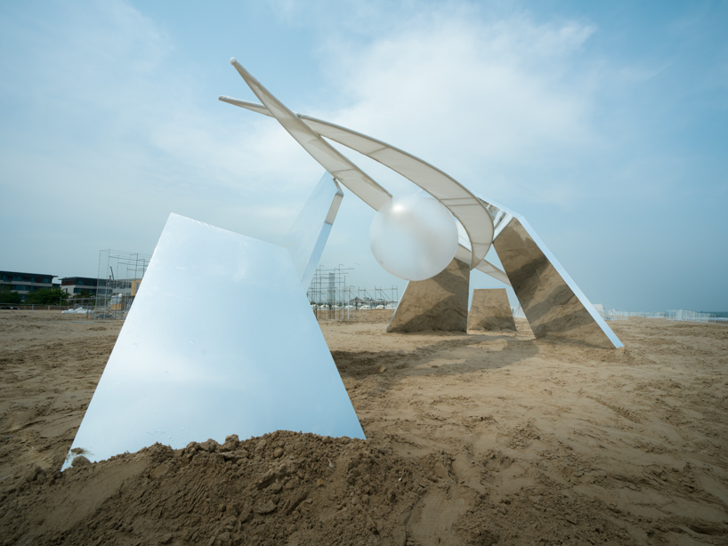 two suspended white wings float around luminous central sphere for oas/s-nest installation