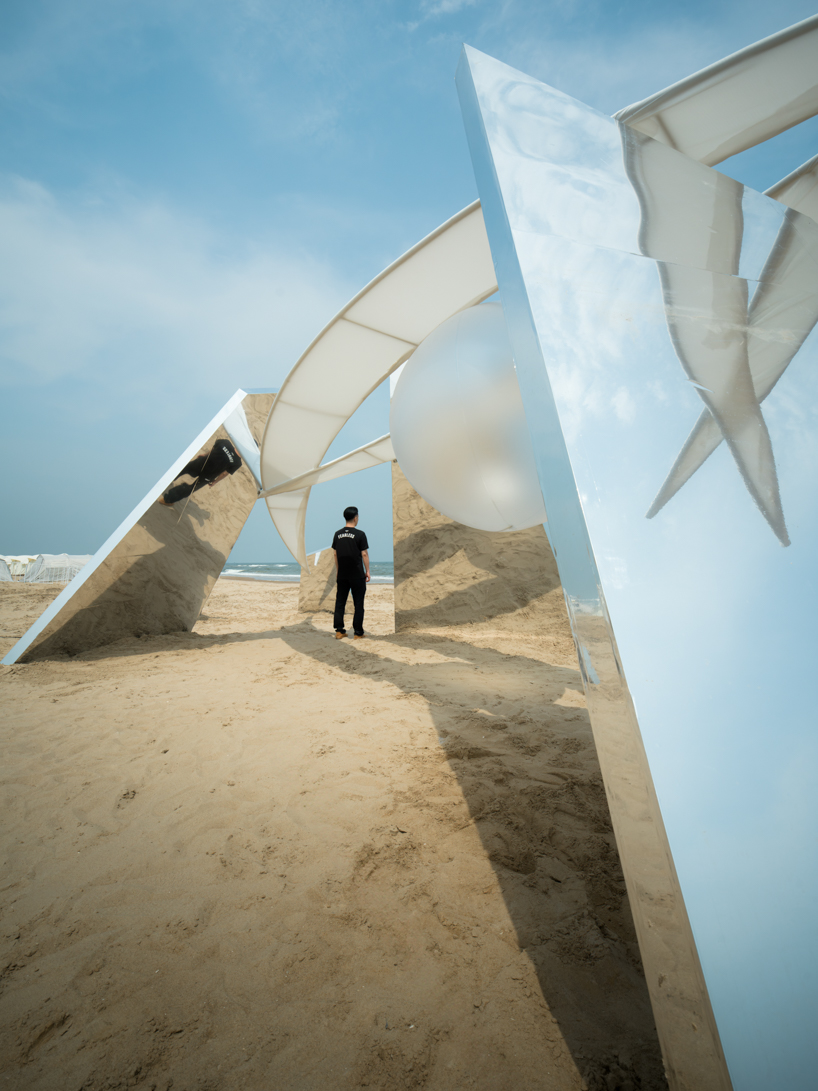 two suspended white wings float around luminous central sphere for oas/s-nest installation