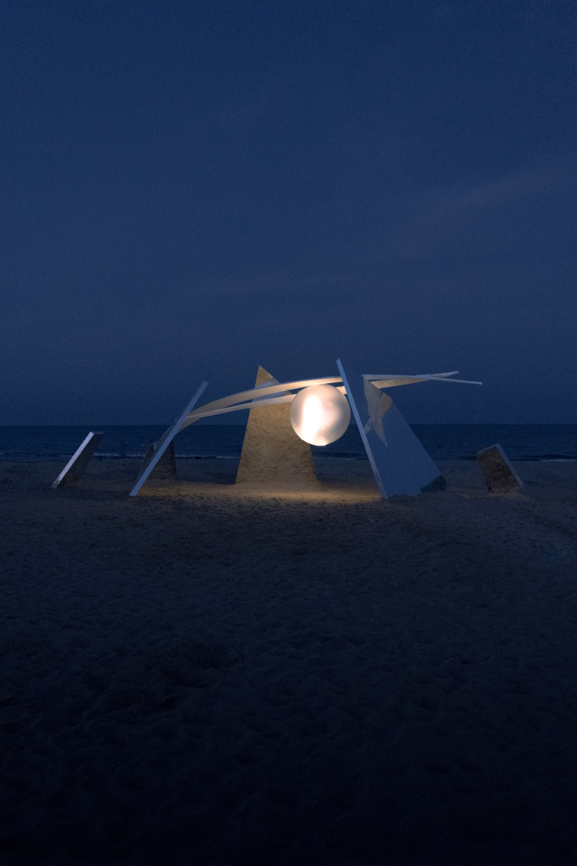 two suspended white wings float around luminous central sphere for oas/s-nest installation