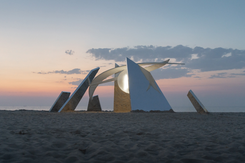 two suspended white wings float around luminous central sphere for oas/s-nest installation