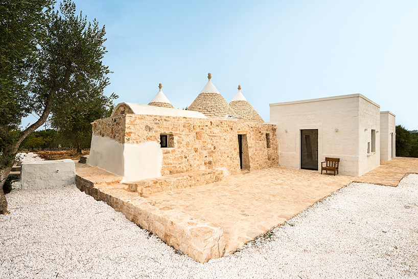 Tres tradicionales edificios trulli con cúpulas de piedra se combinan en una casa contemporánea diseñada por el estudio italiano 8.
