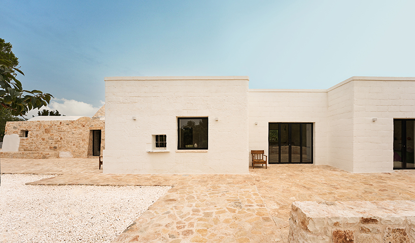 Tres tradicionales edificios trulli con cúpulas de piedra se combinan en una casa contemporánea diseñada por el estudio italiano 8.